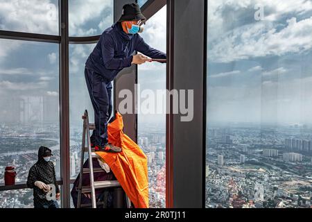 Vietnamesische Arbeiter ersetzen zerbrochene Glasfenster im Landmark 81 Tower, Ho Chi Minh City, Vietnam Stockfoto