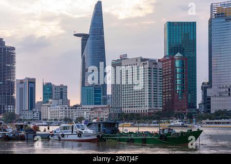 Boote auf dem Saigon River vor Wolkenkratzern und der Skyline des Gebäudes, Ho-Chi-Minh-Stadt, Vietnam Stockfoto