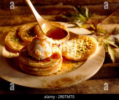 Schottische Pfannkuchen mit Vanilleeis und Ahornsirup Stockfoto