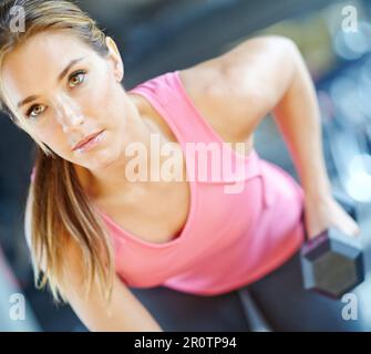 Ich mache große Fortschritte. Eine wunderschöne junge Frau, die im Fitnessstudio trainiert. Stockfoto