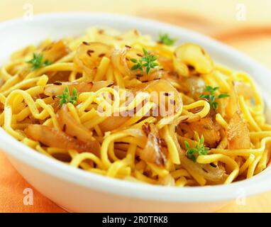 Spätzle gebratene Nudeln mit Zwiebeln und Koriander Stockfoto