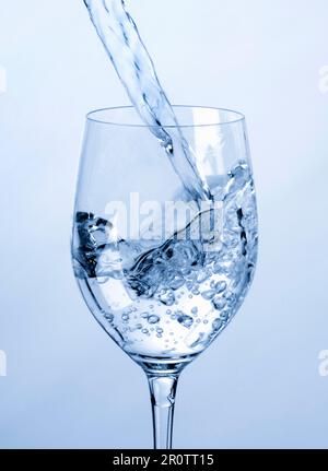 Gießen Wasser in Glas Wein Stockfoto