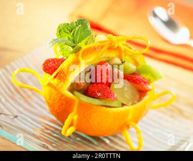 Obstsalat in Orangenkorb Stockfoto