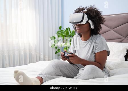 Afrikanische Gaming-Enthusiasten genießen virtuelle Realität auf dem Bett. Stockfoto