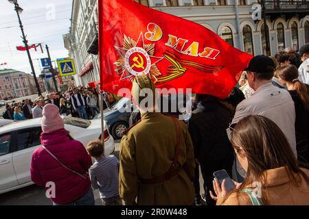 Ein Junge steht an einer Fußgängerüberquerung mit einer Flagge sowjetischer Symbole und der Inschrift „9. Mai“ während der stadtweiten Feier des Siegesfeiertages. Russland feierte den 78. Jahrestag des vollständigen und letzten Sieges im Großen Patriotischen Krieg über Nazideutschland. Der Siegesfeiertag wurde am 9. Mai in vielen Städten des Landes gefeiert, zu den wichtigsten gehörten Sankt Petersburg und Moskau. Tausende von Menschen in Sankt Petersburg gingen auf die Straßen der Stadt, um die Opfer des Zweiten Weltkriegs zu ehren Russland feierte den 78. Jahrestag des vollständigen und letzten Sieges im Großen Patriotischen Krieg über Na Stockfoto