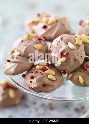 Kleine Schokoladen Baiser mit Pinienkernen und rosa Pfefferkörner Stockfoto