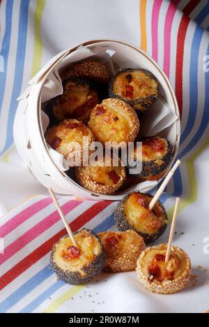 Kleine, lockige Brötchen mit Speck und Käse mit Sesam und Mohnsamen Stockfoto