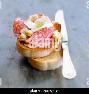 Getrocknete Wurst, Pecorino und Bohnenbroschetta Stockfoto