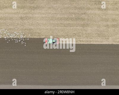 Pflügen des Traktors in der Dröhnenansicht. Bodenbearbeitung und -Vorbereitung für den Traktorpflug. Landwirtschaftlicher Traktor auf dem Feld. Stockfoto