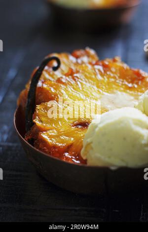 In der Pfanne gebratene Ananas mit Vanillegeschmack und eine Kugel Eis Stockfoto