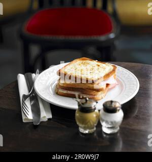 Getoastetes Sandwich mit Schinken und Käse, garniert mit gegrilltem Käse Stockfoto