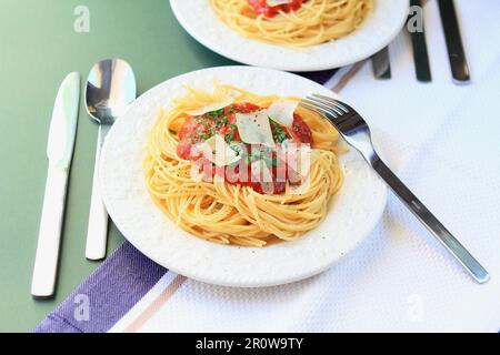 Spaghettis mit Tomatensoße und Käseflocken Stockfoto