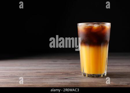 Leckeres erfrischendes Getränk mit Kaffee und Orangensaft auf einem Holztisch, Platz für Text Stockfoto