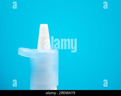 Nasenspray-Flaschen auf blauem Hintergrund, Behandlung einer Erkältung mit Nasenspray. Medizin-Nahaufnahme. Stockfoto