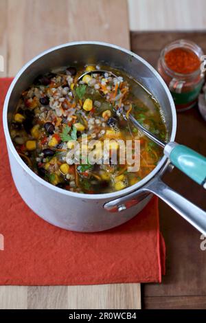 Zubereitung einer Brühe mit Reis, Zuckermais, roten Nierenbohnen und Espelettpepper Stockfoto