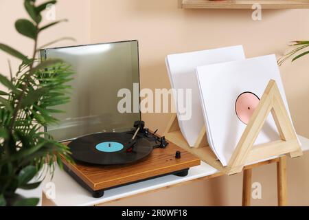 Stilvoller Plattenspieler mit Schallplatte auf Holztisch im Zimmer Stockfoto