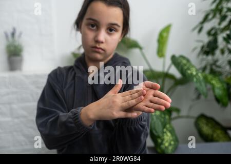 Wunderschönes, lächelndes, taubes Mädchen, das Gebärdensprache benutzt. Stockfoto