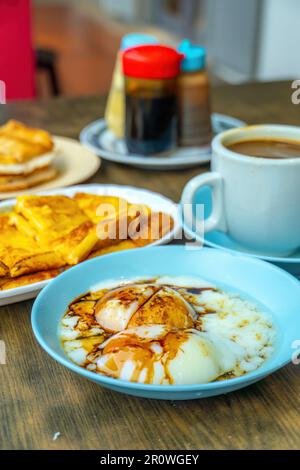 Traditionelles Frühstücksset und Kaffee, gekochte Eier und Toast, beliebt in Singapur und Malaysia Stockfoto