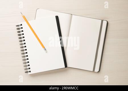 Notizbücher und Bleistift auf weißem Holztisch, Draufsicht Stockfoto