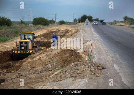 Südkasachstan - April 26 2012: Entwicklung der Autobahn Westeuropa-Westchina. Bodenarbeiten mit Bulldozer Stockfoto