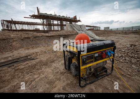 Südkasachstan - April 26 2012: Entwicklung der Autobahn Westeuropa-Westchina. Bau einer Brücke an der Straßenkreuzung. Generator Dieselmotor ein Stockfoto