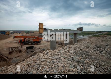 Südkasachstan - April 26 2012: Entwicklung der Autobahn Westeuropa-Westchina. Bau von Brücken von Straßenverbindungen gegen graue Sturmwolken Stockfoto