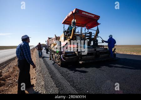 Provinz Kyzylorda, Kasachstan, 29. April 2012: Bau der Autobahn Westeuropa-Westchina. Dynapac Straßenmaschine und Asphaltlagen Stockfoto