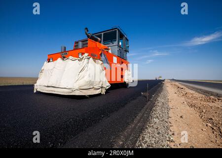 Provinz Kyzylorda, Kasachstan, 29. April 2012: Bau einer Straße zwischen Westeuropa und Westchina. Hamm Asphaltverdichter auf neuen Asphaltlagen Stockfoto