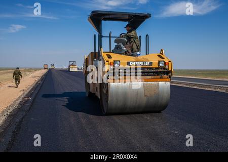 Provinz Kyzylorda, Kasachstan, 29. April 2012: Bau der Autobahn Westeuropa-Westchina. Caterpillar-Asphaltverdichter flachen neuen Asphalt Stockfoto