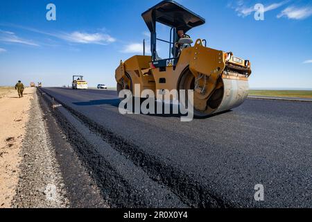 Provinz Kyzylorda, Kasachstan, 29. April 2012: Bau der Autobahn Westeuropa-Westchina. Caterpillar-Asphaltverdichter flachen Asphalt Stockfoto