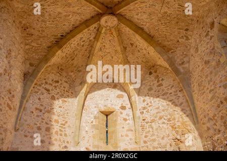 Aus der Nähe antike Kirche und ein kleines Fenster in den Festungen einer Burg in der Altstadt von Tossa de Mar, Costa Brava, Katalonien, Spanien. Stockfoto