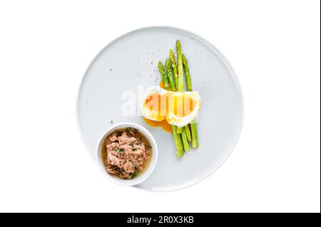 Gebackener Mini-Spargel mit Ei und Thunfisch. Isoliert auf weißem Hintergrund Stockfoto