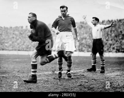 Association Football Photo, Western Mail and Echo, 30. Dezember 1950. Ein Action-Shot aus dem Spiel zwischen Cardiff City und Preston North End, im Ninian Park. Stadt verlor 0-2. Das Foto zeigt den Torwart Jimmy Gooch in Cardiff, der den Ball in seiner Gegend sammelt. Einige Oberflächenfalten auf dem Original. Stockfoto