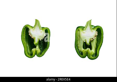 Grüne Paprika, zwei Hälften, schneiden. Schwarzer Hintergrund. Draufsicht. Platz für süßen Pfeffer, zwei Hälften. Isoliert auf weißem Hintergrund Stockfoto