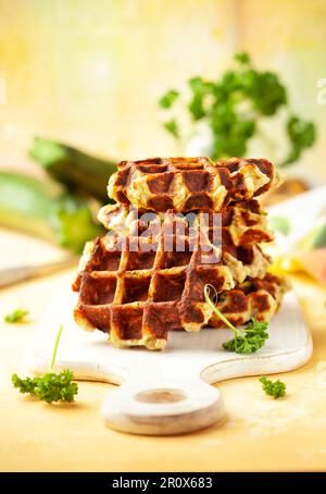 Hausgemachte kohlenhydratarme Zucchini-Waffeln auf weißem Holzbrett auf gelbem Hintergrund. Konzept der Keto-Diät. Stockfoto