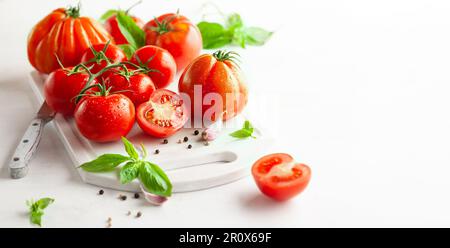 Konzept für gesunde Speisen mit frischen, reifen Tomaten, Basilikum, Knoblauch und Gewürzen. Sauberes Essen Stockfoto