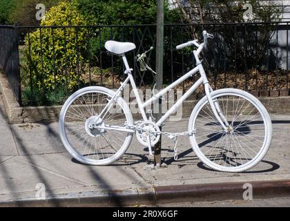 Ein komplett weißes Fahrrad, ein Ghost Bike installiert, um an einen tödlichen Fahrradunfall zu erinnern. Dies ist die 94. St & 40. Drive in Elmhurst, Queens, New York. Stockfoto