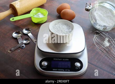 Digitale Küchenwaage mit Mehl auf der Oberseite - Vorbereitung für Backwaren-Konzept Stockfoto