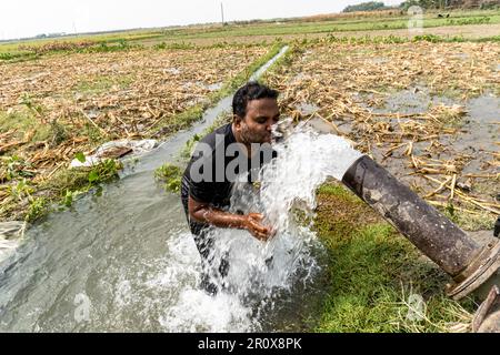 Hygienische Reinigungsroutine im Freien. Ein Mann, der duscht und Haare unter Wasser wäscht, die von Motorwassertropfen fallen Stockfoto