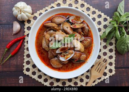 Gebratene Muscheln mit Chilipaste und Basilikum – asiatische Gerichte, auf Thai Hoi Lai Pad Prik Paow genannt Stockfoto