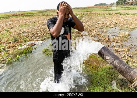 Ein gutaussehender Kerl, der draußen unter kühlen Wassertropfen steht. Haut- und Körperpflege. Männliche Körperpflege Und Alltagshygiene-Routine-Konzept Stockfoto