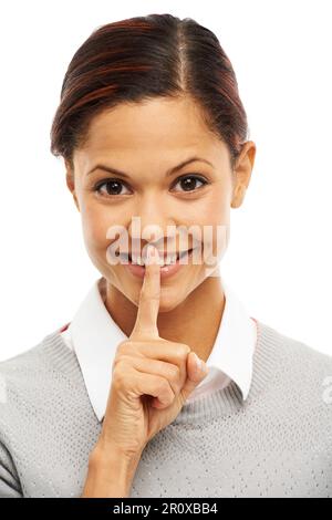 Ich bin gut darin, Geheimnisse zu bewahren. Studioporträt einer attraktiven jungen Frau mit dem Finger auf den Lippen isoliert auf weiß. Stockfoto