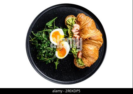 Frühstück, Brunch Croissant mit heißem Räucherlachs, Avacado. Gartengrüner Salat mit Rucola und Ei. Isoliert auf weißem Hintergrund Stockfoto