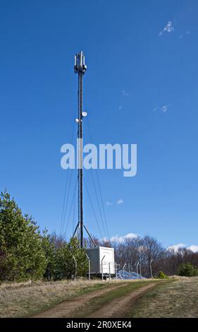 Ein Frühlingswald mit einer Wiese und einer Antenne, die mit Solarbatterien betrieben wird, Plana Mountain, Bulgarien Stockfoto