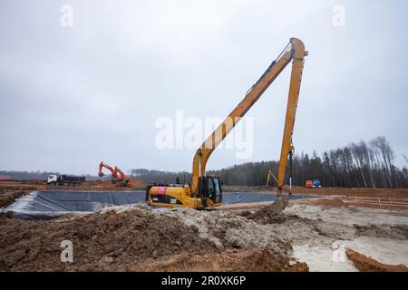 USt-Luga, Oblast Leningrad, Russland - 16. November 2021: Caterpillar-Bagger mit langer Auslegergrube Stockfoto