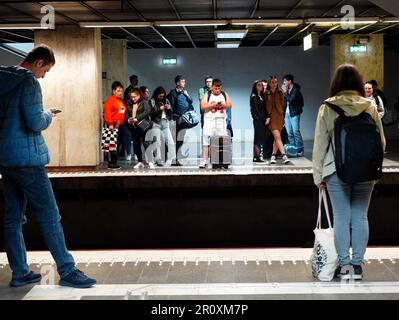 Junge Leute, die am 1. Mai 2023 in der U-Bahn-Station in Bukarest, Rumänien, auf die U-Bahn warten Stockfoto