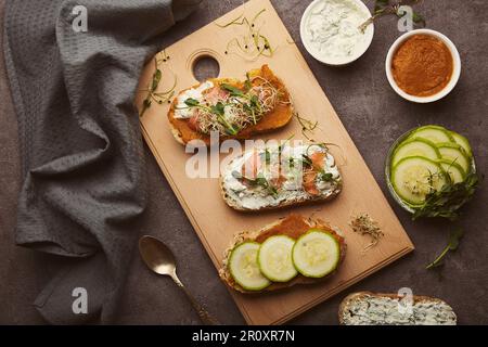 Gesunde Sandwiches mit Zucchini-Aufstrich und natürlichem Joghurt, geräuchertem Lachs. Kalorienarm, FODMAP, KETO-Diät, Superfood Flat Lay Stockfoto