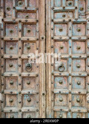 Der alte Türknauf aus Messing auf dem großen Holztor im chinesischen Stil, ein lokales Dorf auf dem Land, Vorderansicht mit Kopierraum. Stockfoto