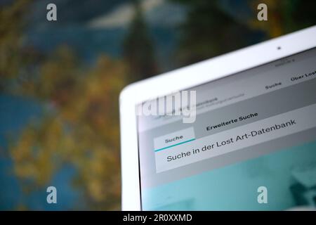 Stuttgart, Deutschland. 09. Mai 2023. Ein Tablet mit der in einem Browser geöffneten Datenbank für verlorene Kunst ist vor einem Gemälde zu sehen. Kredit: Marijan Murat/dpa/Alamy Live News Stockfoto