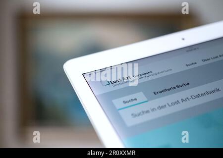 Stuttgart, Deutschland. 09. Mai 2023. Ein Tablet mit der in einem Browser geöffneten Datenbank für verlorene Kunst ist vor einem Gemälde zu sehen. Kredit: Marijan Murat/dpa/Alamy Live News Stockfoto